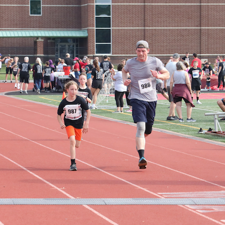 Kids and adult cross the finish line at the Derby Dash